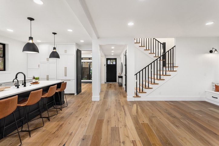 Un intérieur moderne, avec un escalier et du parquet, dans les tons blancs et noirs